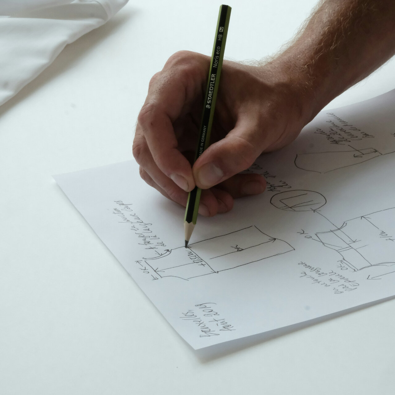 using a pencil to draw a rough prototype for metal machining prototyping services